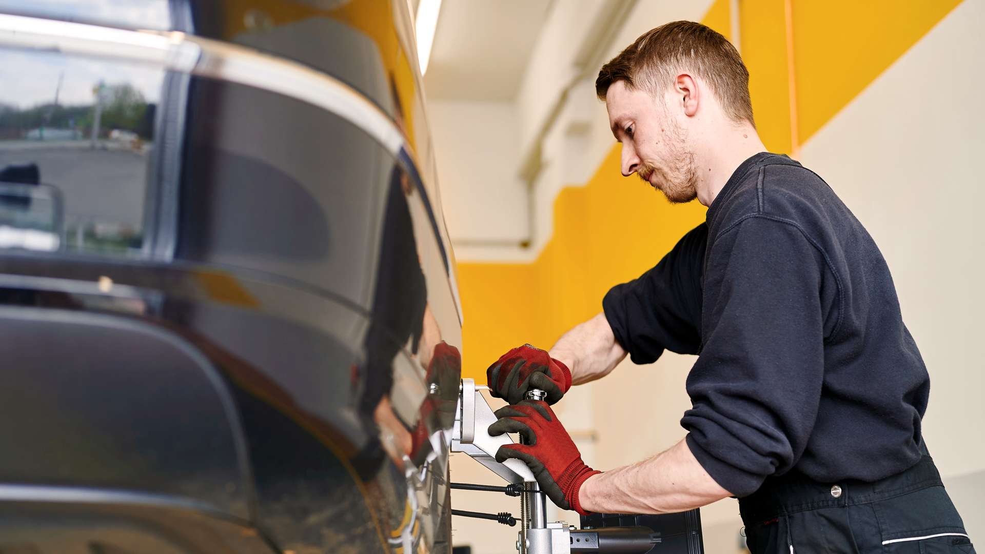 Mitarbeiter bei der Achsvermessung im Seitenprofil