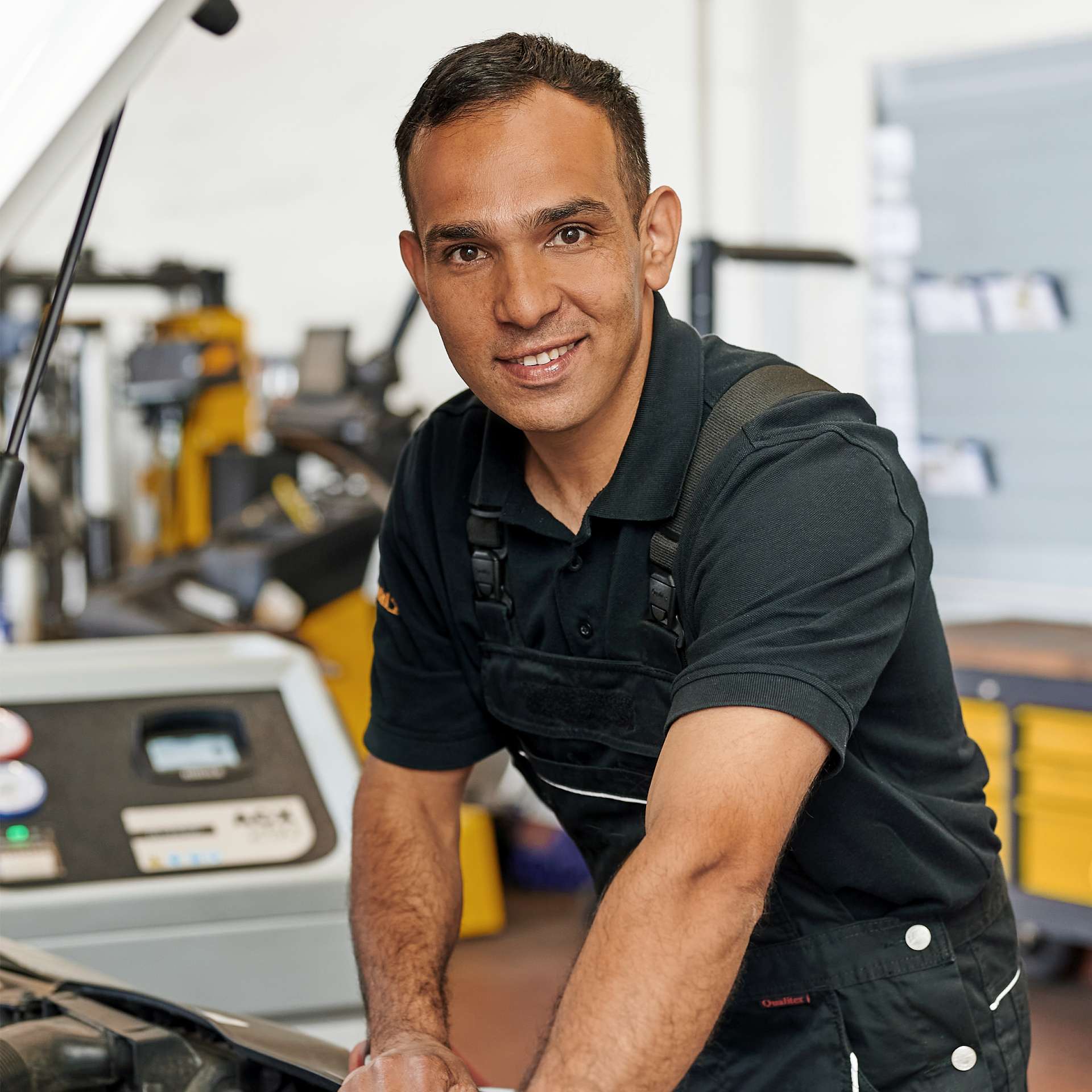 Mechaniker schaut lächelnd in Kamera