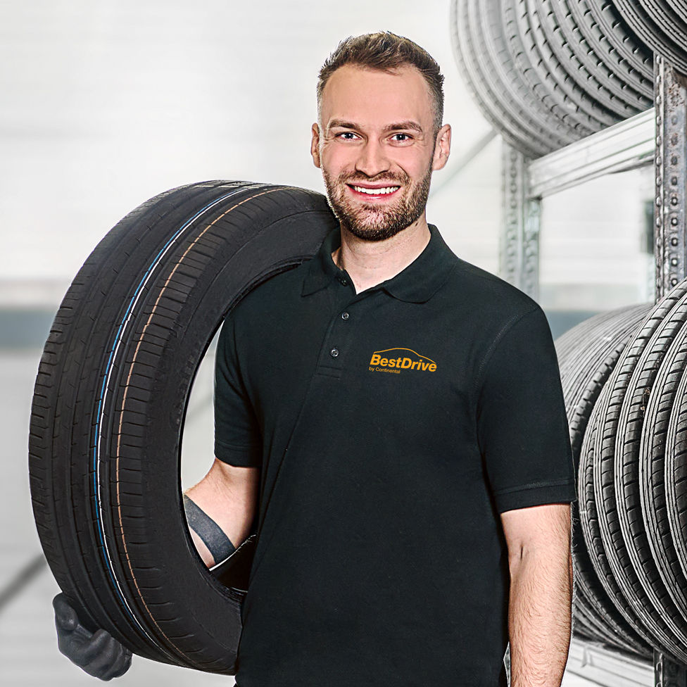 BestDrive Mitarbeiter trägt einen Reifen