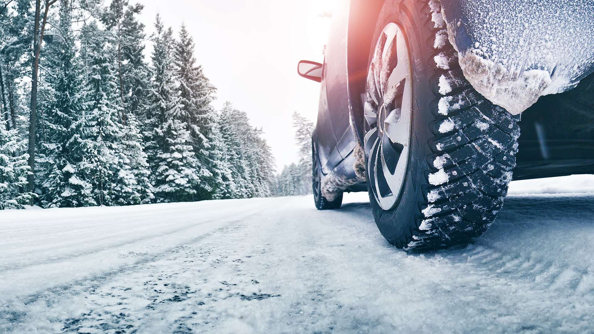 Closeup of car tires in winter on the road covered with snow