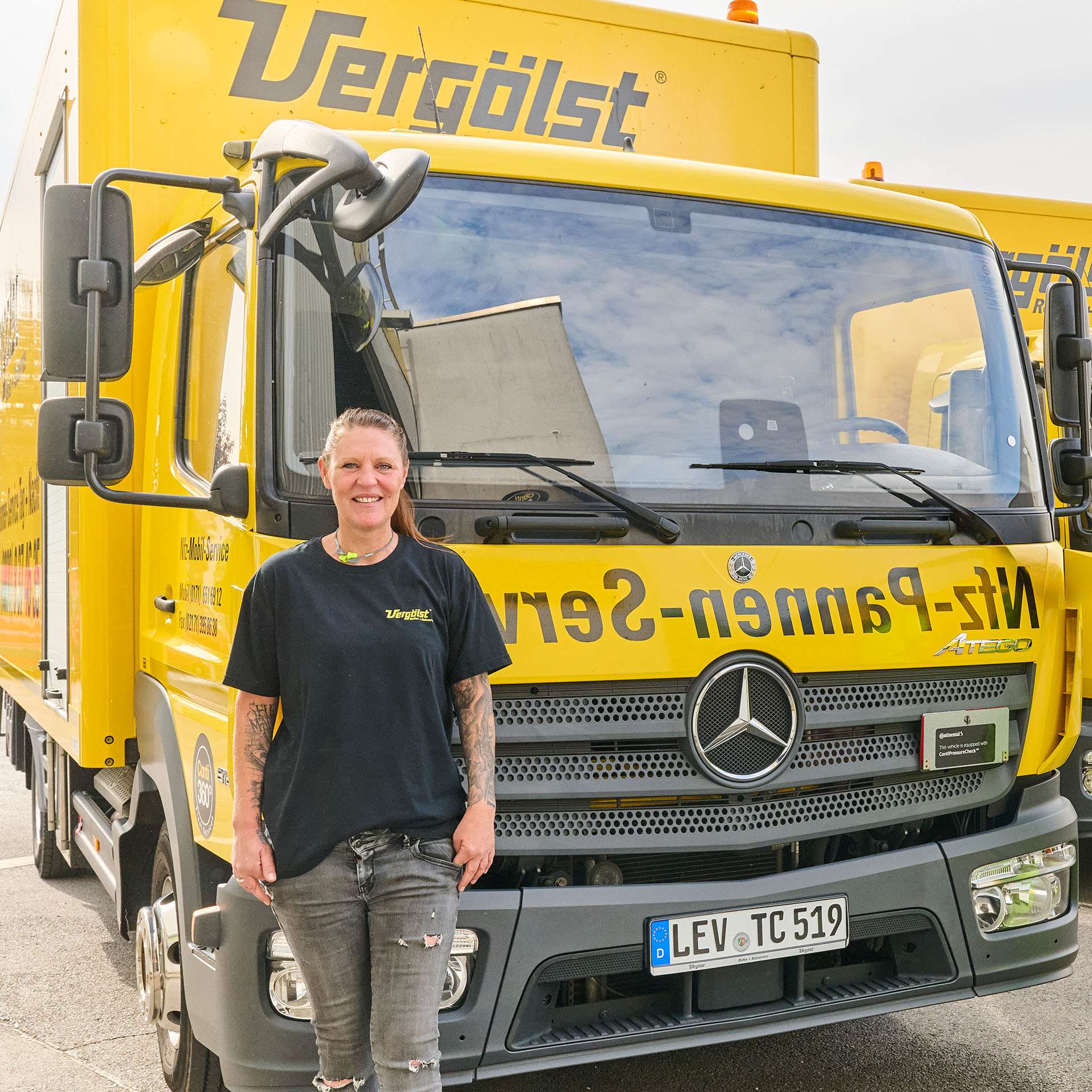 Frau steht vor Lkw im Werkstattkontext