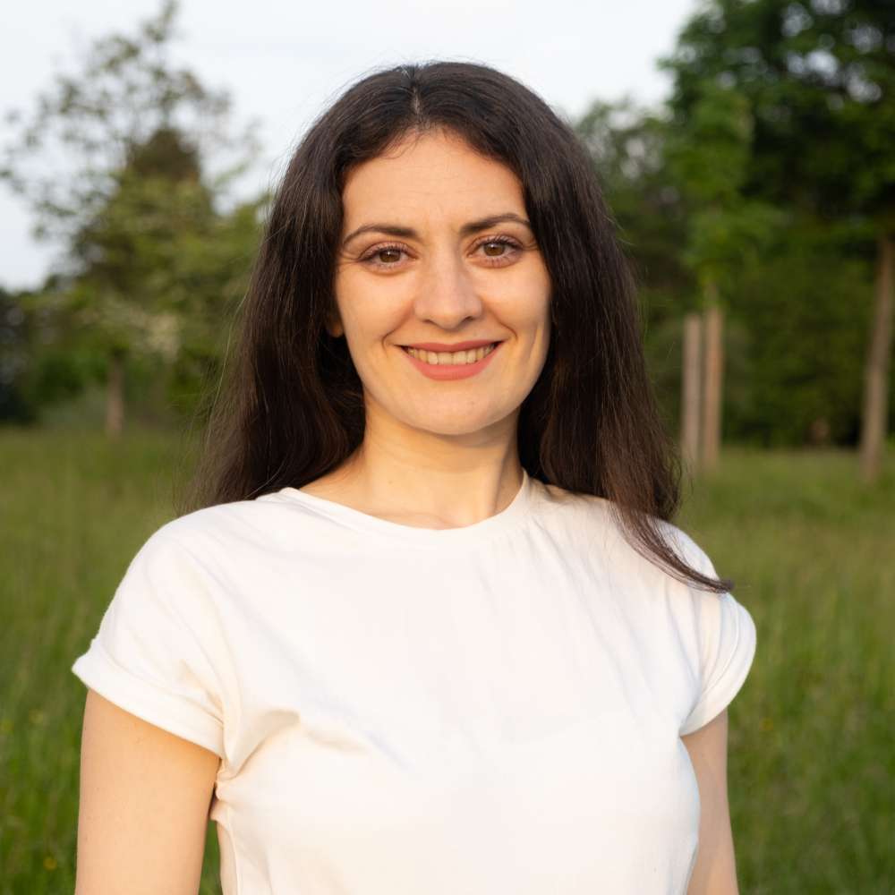 Portrait of a 35-year-old brunette woman looking at the camera smiling in nature