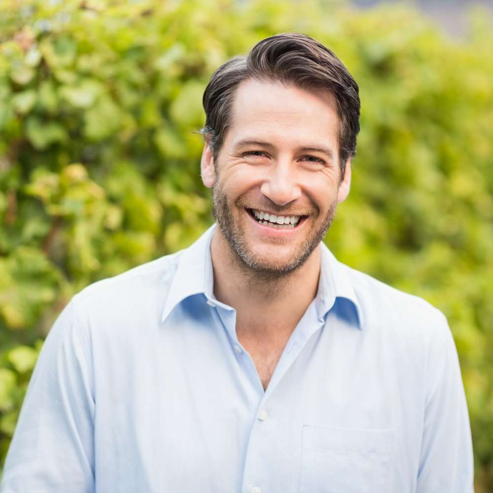 Young happy man smiling at camera in the grape fields