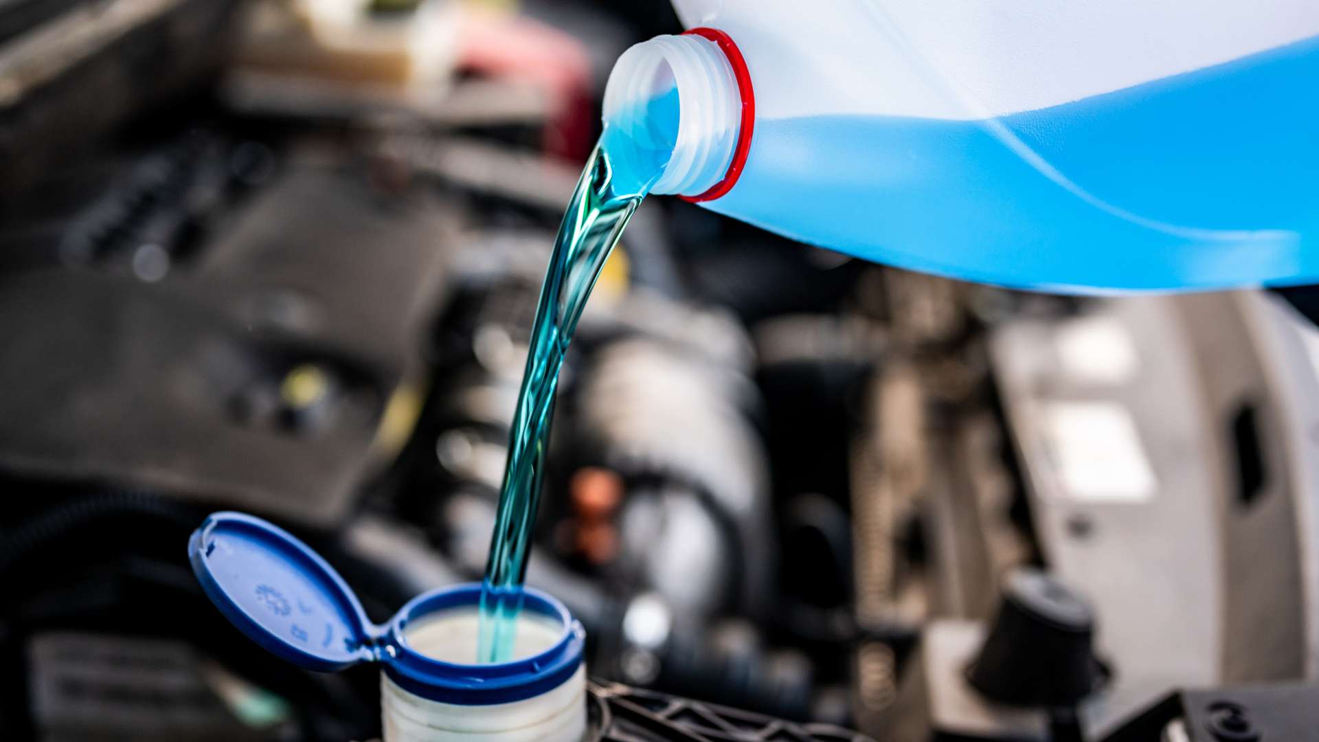 Pouring antifreeze. Filling a windshield washer tank with an antifreeze in winter cold weather.