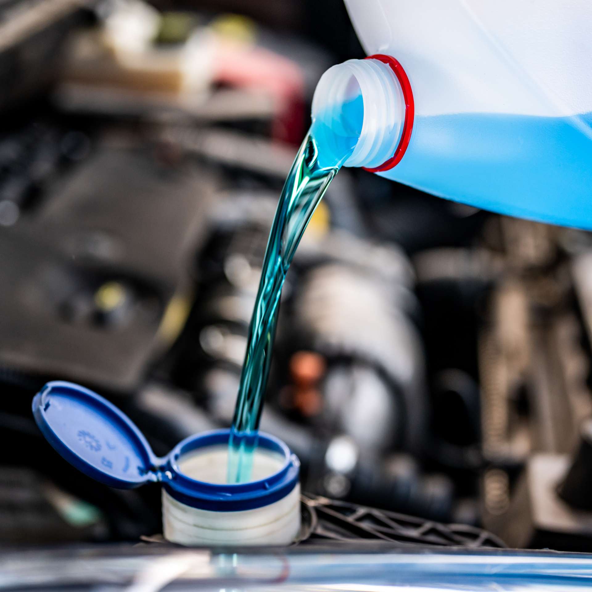 Pouring antifreeze. Filling a windshield washer tank with an antifreeze in winter cold weather.